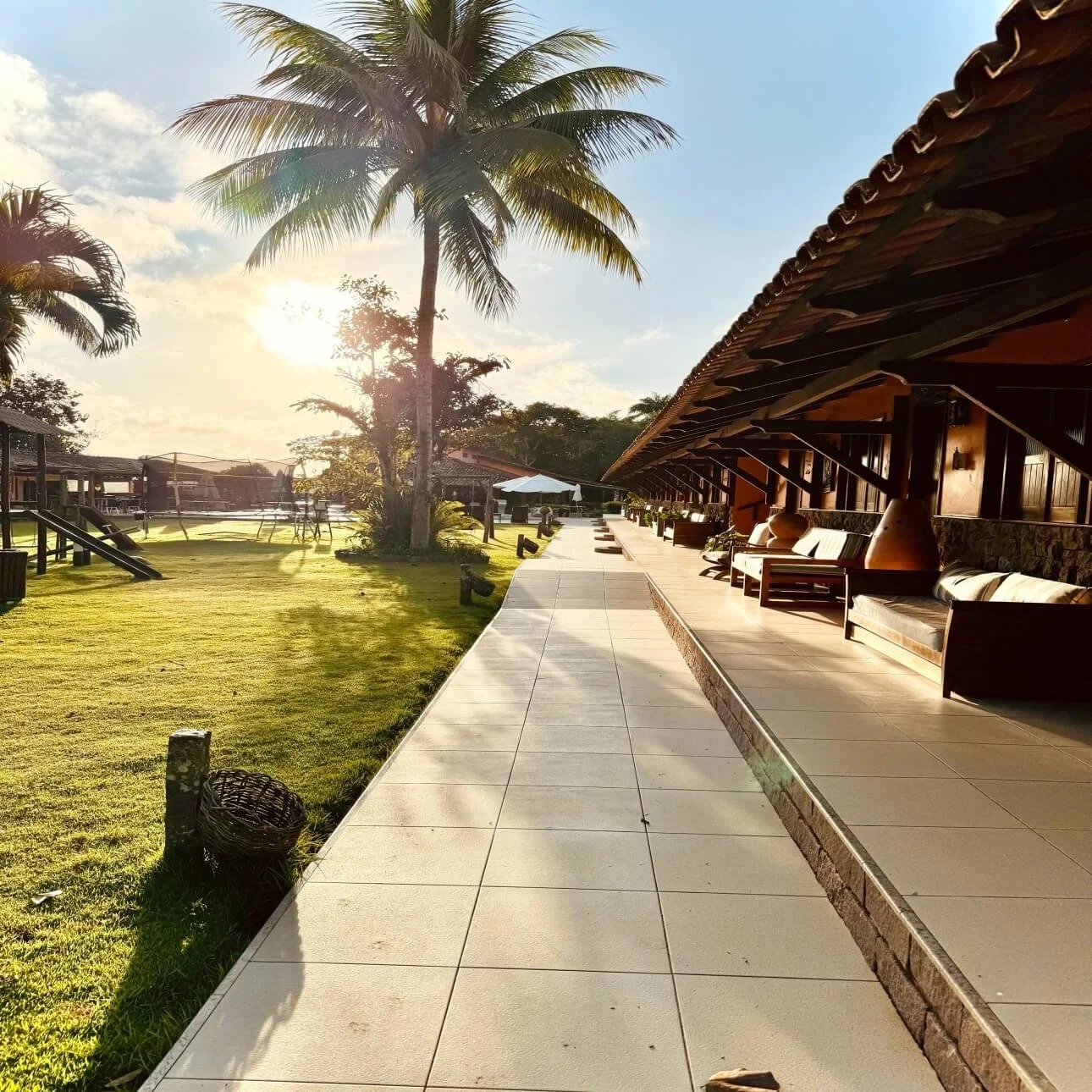 Área externa de hospedagem com jardins e estrutura de descanso